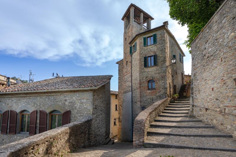 Steintreppe zur Stadtturm von Montone, zwischen mittelalterlichen Gassen und Steinhäusern.