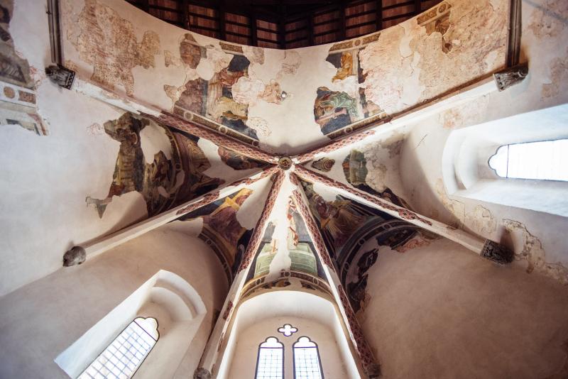 Voûtes ornées de fresques de l’église San Francesco à Montone, avec des scènes sacrées médiévales et des fenêtres gothiques.