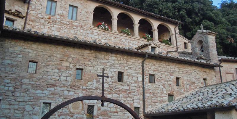 Eremo delle Carceri: ein altes Steinkloster auf dem Monte Subasio, eingebettet in Grün und franziskanische Spiritualität.