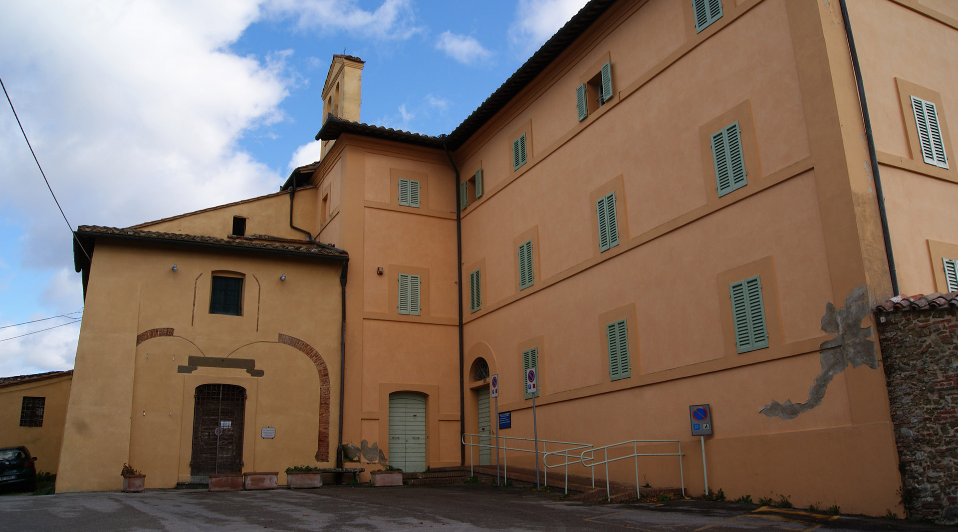 Vista panoramica dell'esterno della Chiesa di San Sebastiano, con la sua facciata semplice rivestita di intonaco, che riflette un'architettura sobria e modesta.