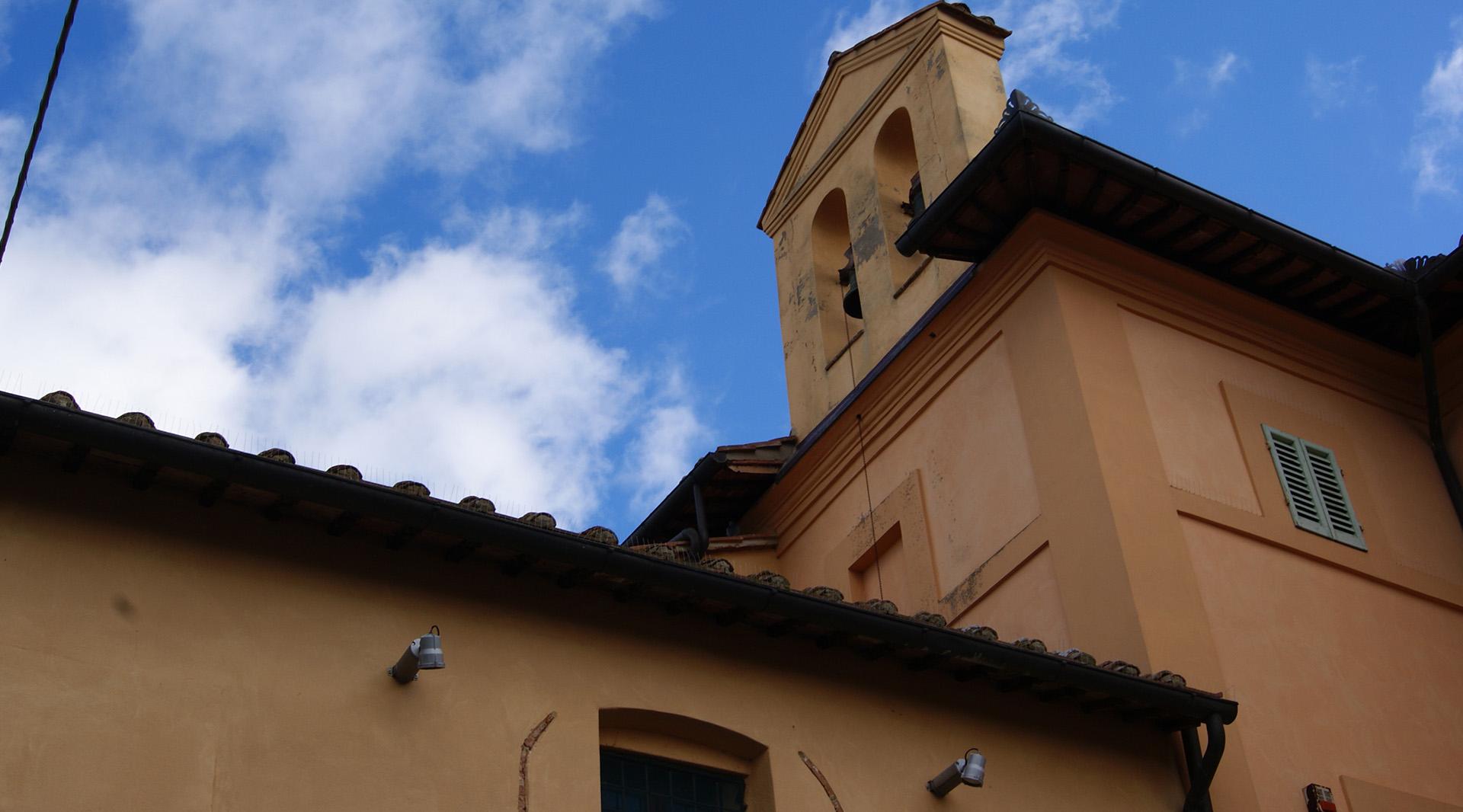 Prospettiva esterna della Chiesa di San Sebastiano, con il tetto a spiovente e un piccolo campanile laterale