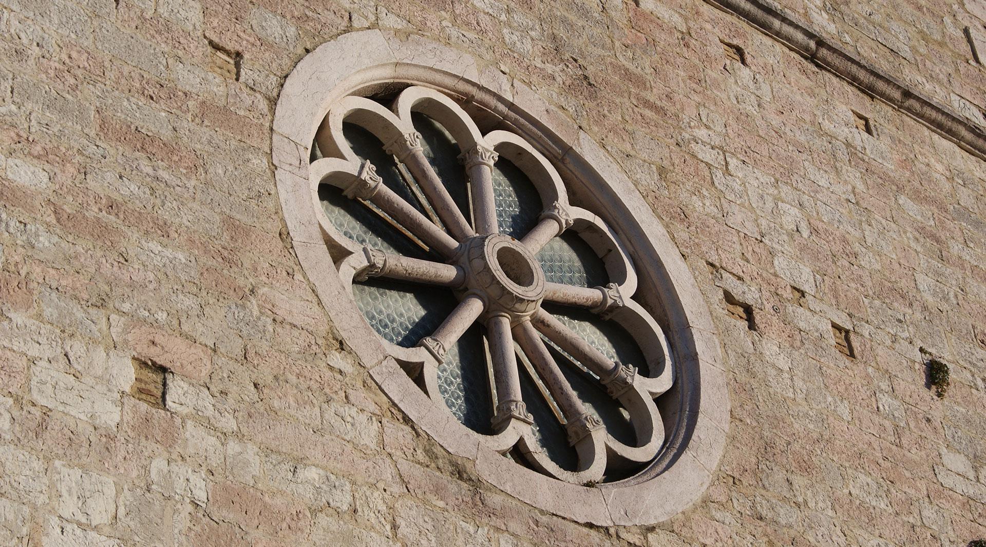 Facciata in pietra della Chiesa di San Giovanni a Vallo di Nera con campanile a vela a due campane e rosone centrale