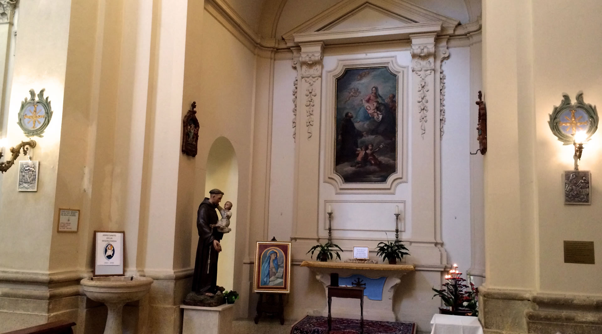 Seitenkapelle der Kirche von Giove mit Andachtsstatue, Altar und gerahmtem sakralem Gemälde.