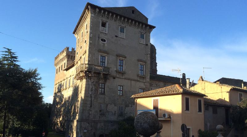 Château de Giove, ancien palais fortifié en pierre avec tour, illuminé par le soleil couchant dans le village ombrien.