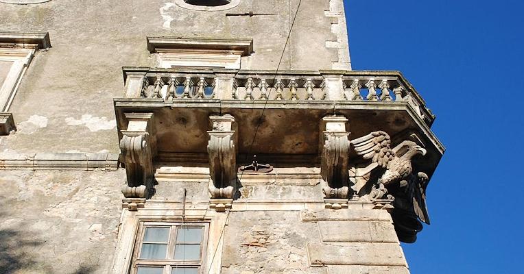 Stone balcony of the Castle of Giove with carved corbels and a decorative eagle on the façade.