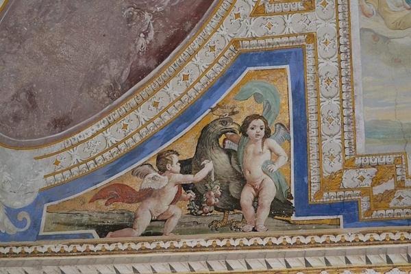 Fresco in the Castle of Giove with cherubs and a decorative eagle within a painted frame.