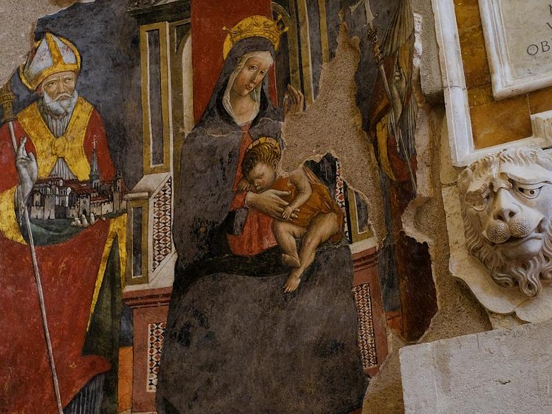 Affreschi dai colori vivaci che raffigurano San Benedetto che sorregge la città di Norcia e una Madonna in trono