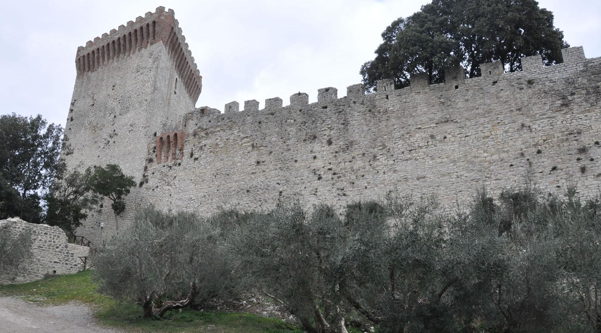 External view of the ancient walls of the Rocca del Leone, featuring arrow slits that offer panoramic glimpses. One of the well-preserved towers stands as a testament to the historic fortification.