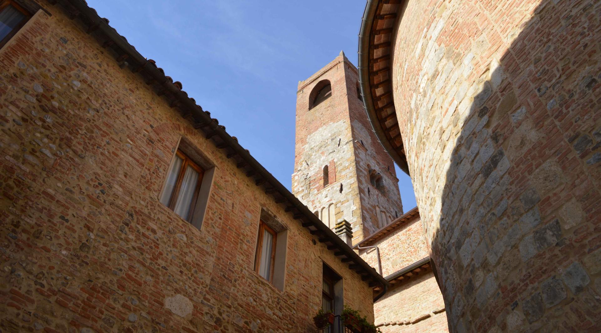 Side view of the church of Santi Gervasio e Protasio, with the bell tower rising majestically in the background.