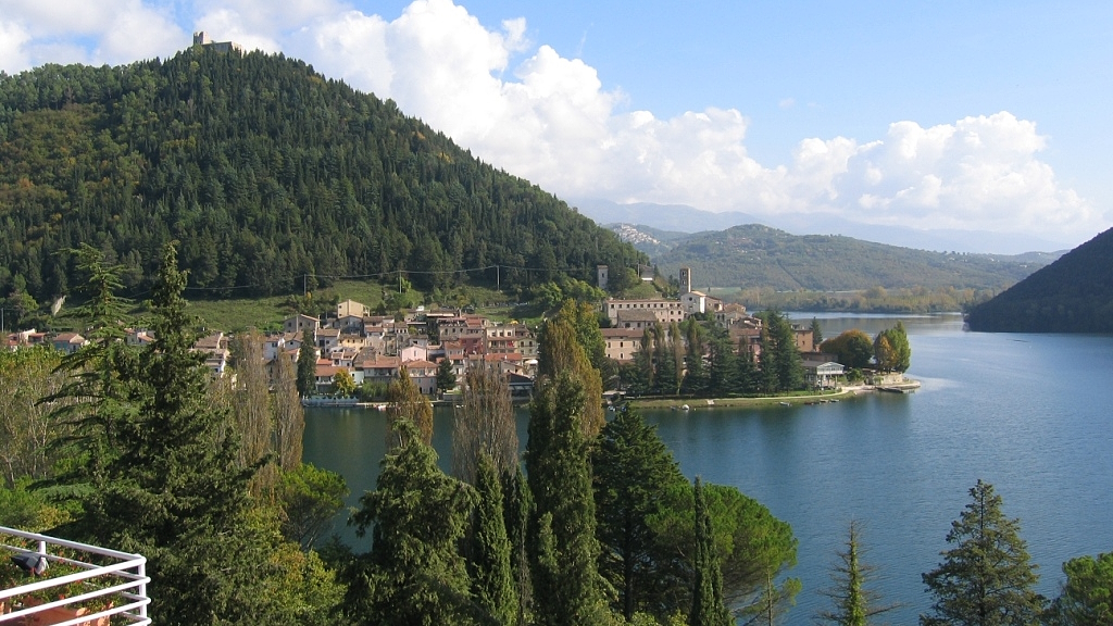 The village of Piediluco, at the foot of the mountain with the remains of the fortress, overlooking the lake on a sunny day.