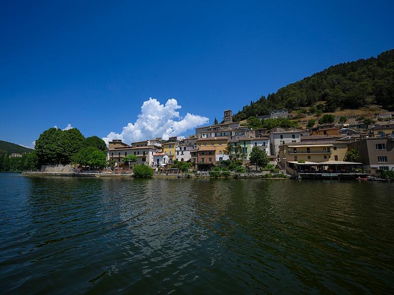 The village of Piediluco overlooking the lake on a sunny day, with its bell tower dominating the landscape.