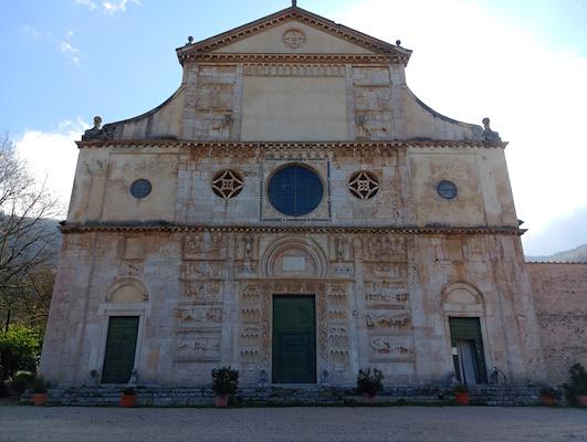 Facciata della chiesa di San Pietro con i suoi bassorilievi in una soleggiata giornata di primavera, costruita ai piedi di Monteluco