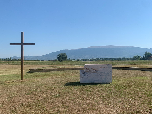 Croix en bois et sculpture avec des oiseaux sur une prairie, lieu du Sermon aux oiseaux de Saint François à Piandarca