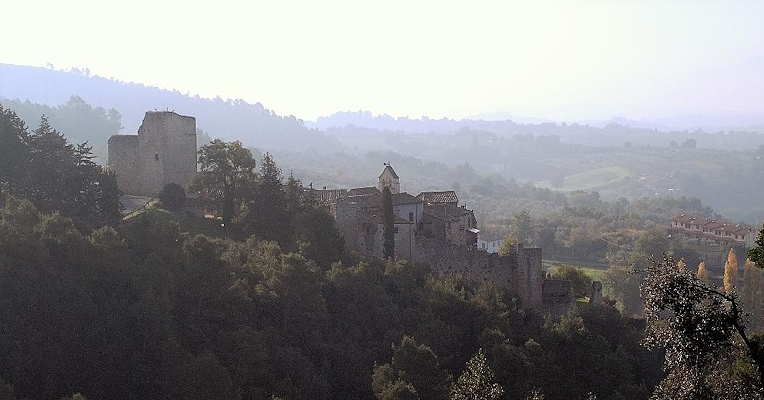 Poggio di Otricoli, an ancient fortified village, rises among Umbrian woods and hills shrouded in mist.