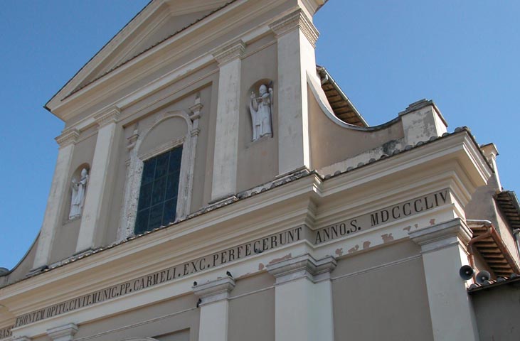 Detail der Fassade der Basilika des heiligen Valentin mit Nischenstatuen und Inschriften unter klarem Himmel