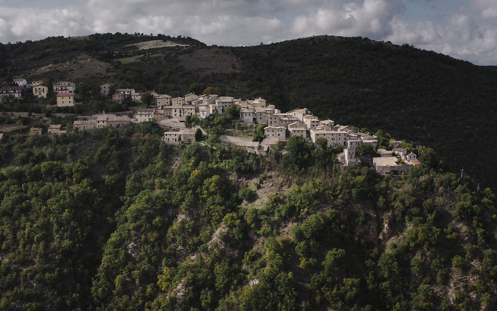 The layout of the medieval castle of Poggiodomo perched on a rocky spur amidst unspoilt nature and green woods
