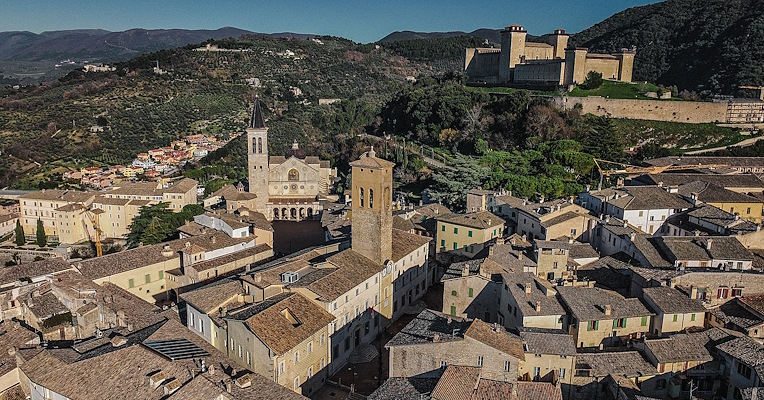 Veduta panoramica di Spoleto con il Duomo, la Rocca Albornoziana e tetti storici incastonati tra colline umbre.