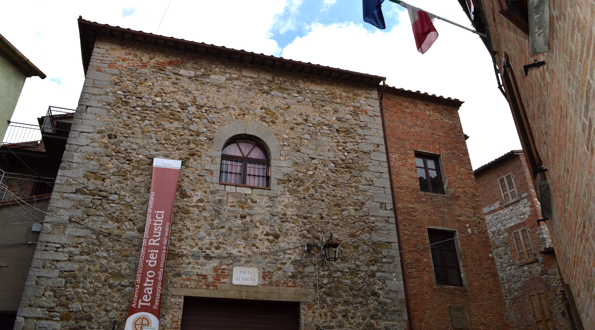Steinernen Fassade des Teatro dei Rustici in Monteleone di Orvieto mit Rundbogenfenster in einer Gasse des Dorfes.