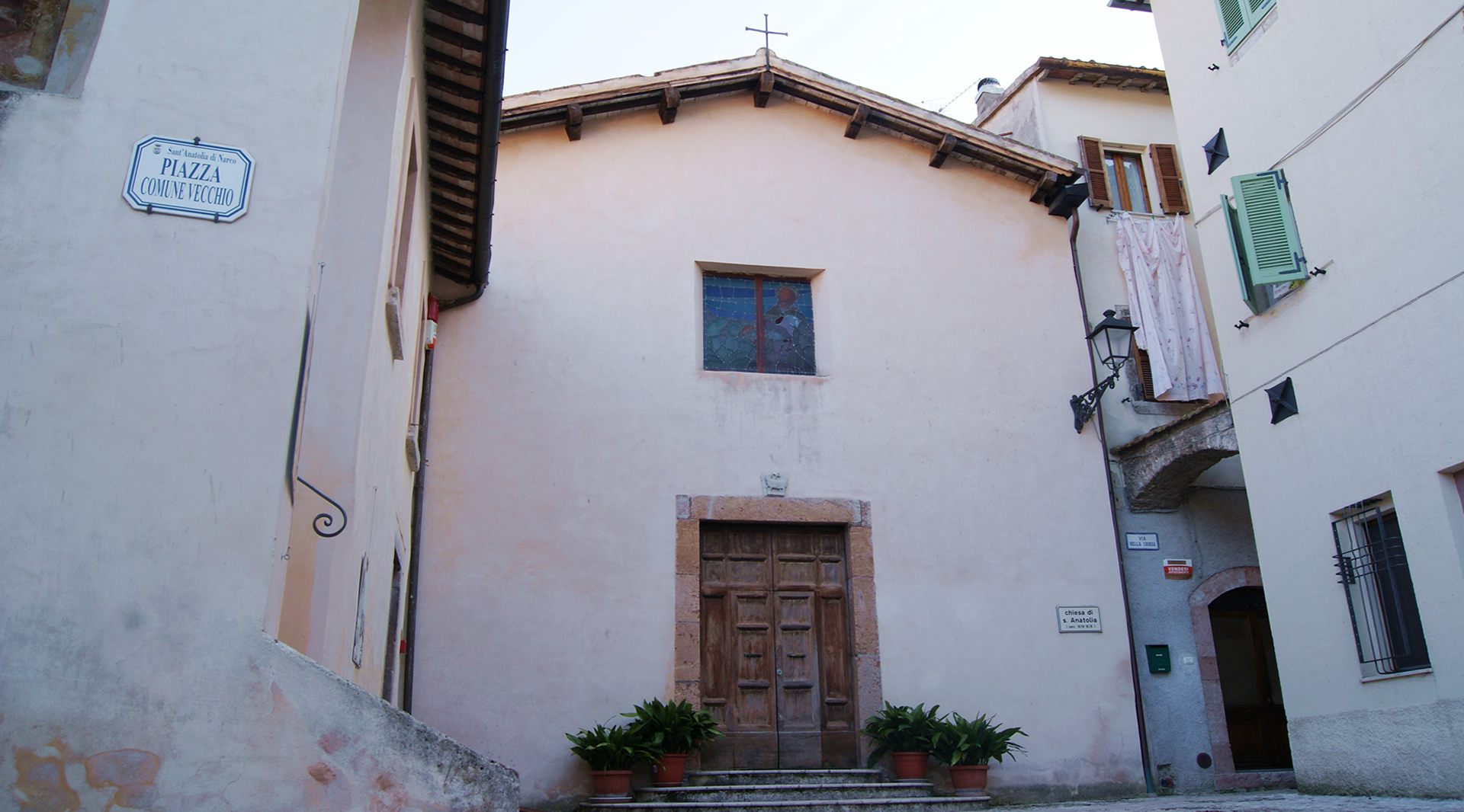 Schlichte Fassade der Kirche Sant’Anatolia, gelegen an der Piazza Comune Vecchio, eingerahmt von historischen Gebäuden.