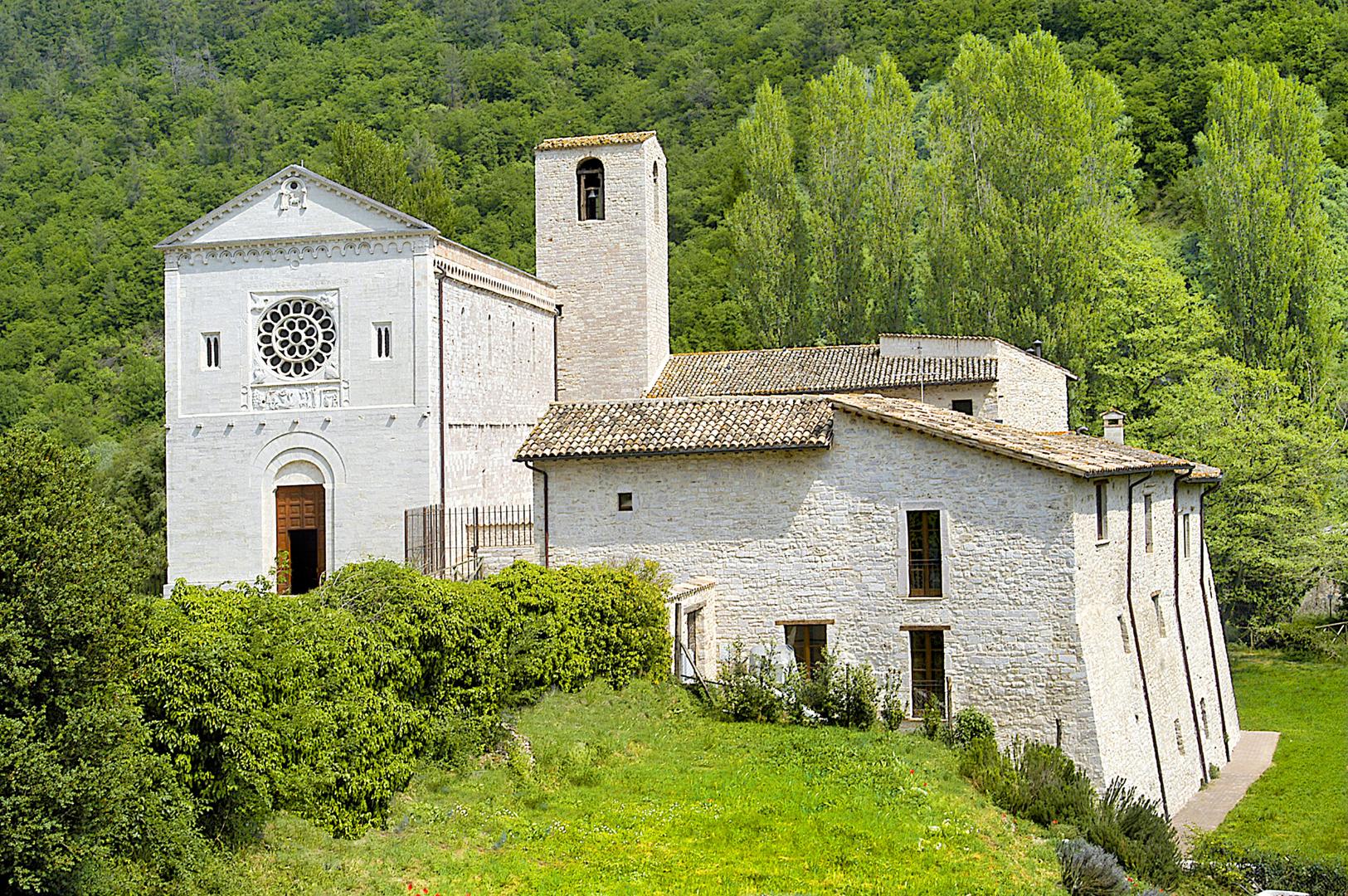 Abbazia dei Santi Felice e Mauro immersa nella natura in primavera con la chiesa sulla sinistra dell’immagine, il campanile al centro e le strutture dell’antica abbazia sulla destra, oggi utilizzate come struttura recettiva