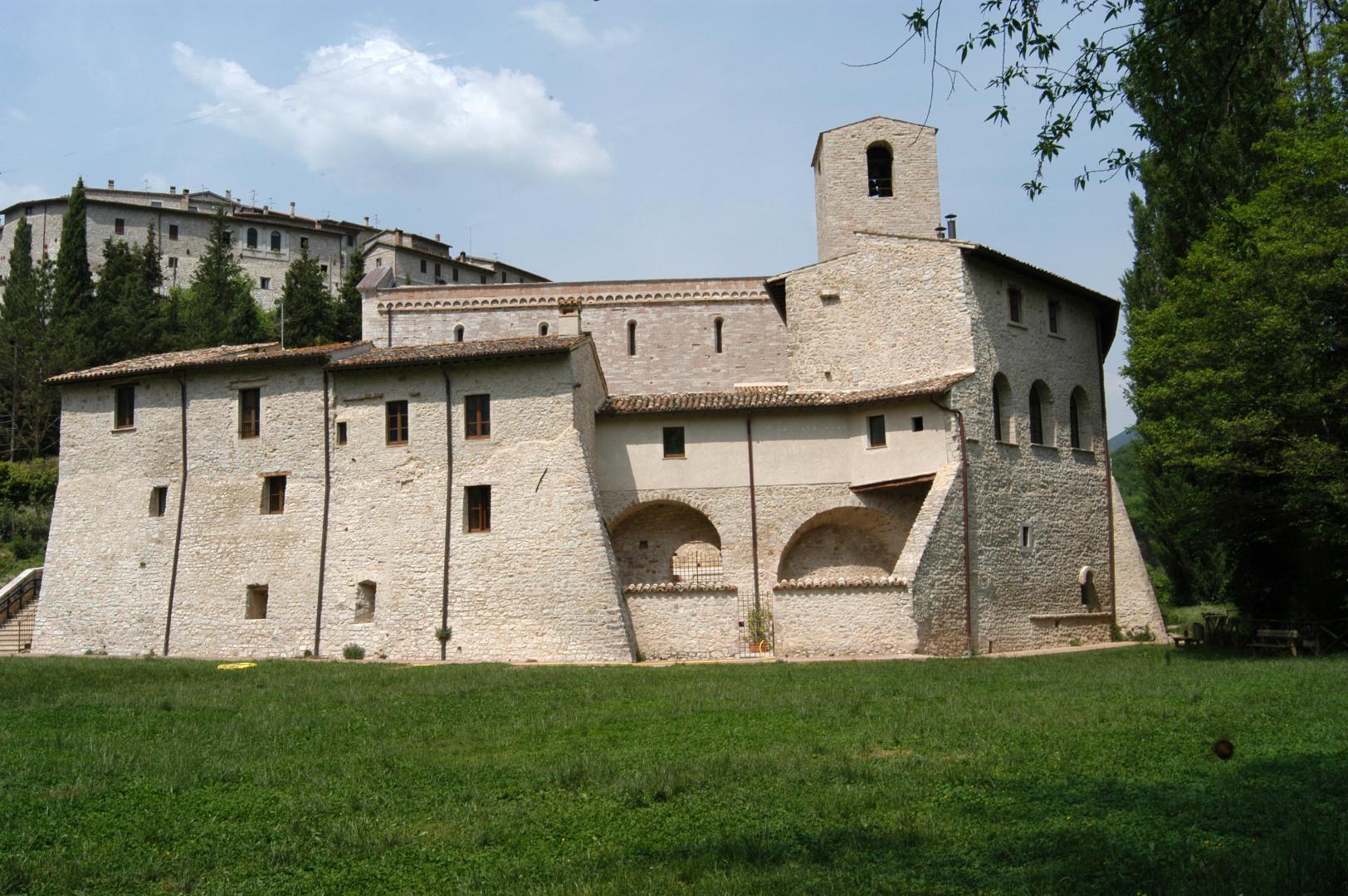Prato verde posto sulla parte retrostante dell’abbazia dei Santi Felice e Mauro, con il paese di Castel San Felice sullo sfondo