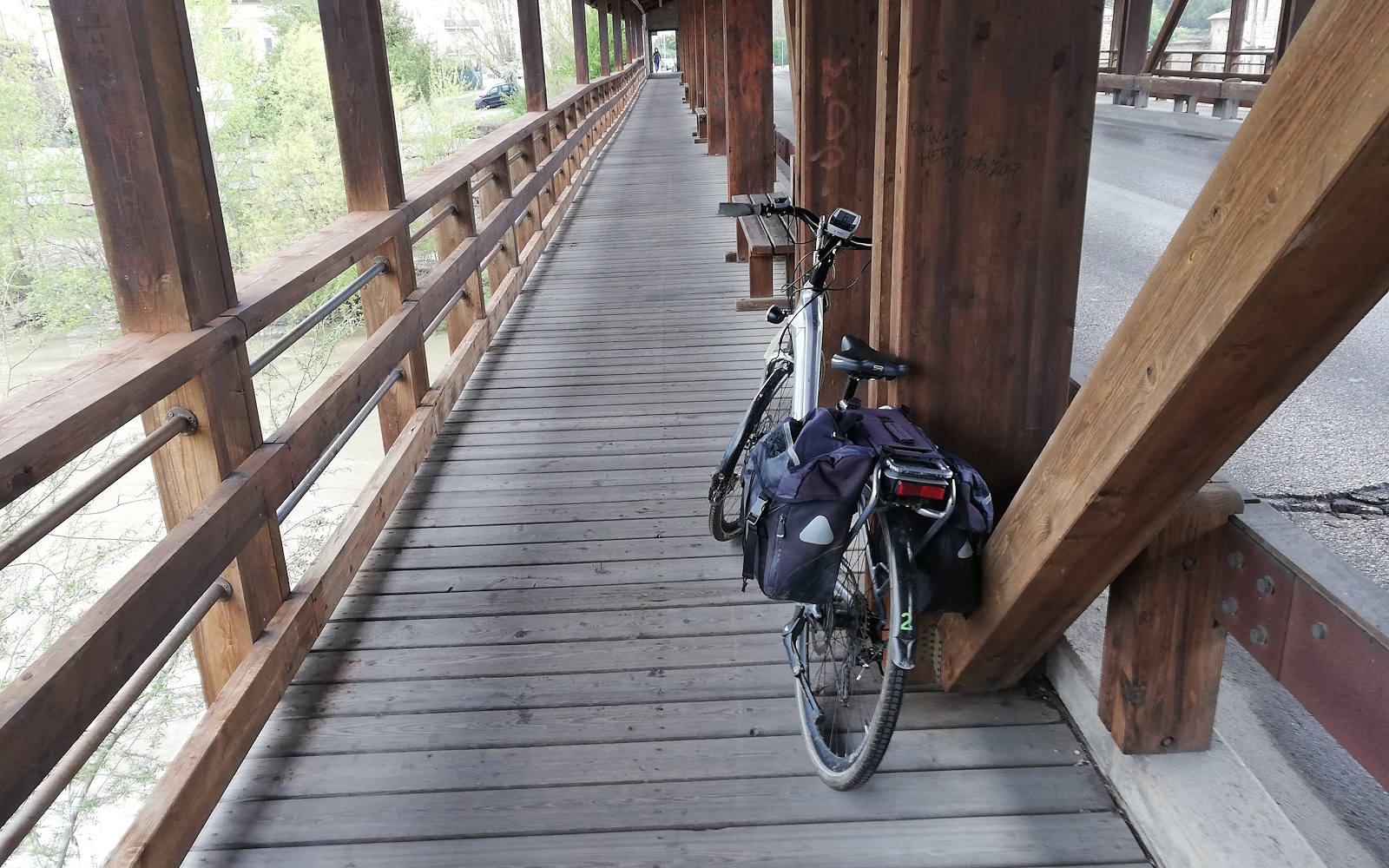 Bicycle resting on the beam of a wooden bridge along a cycle lane
