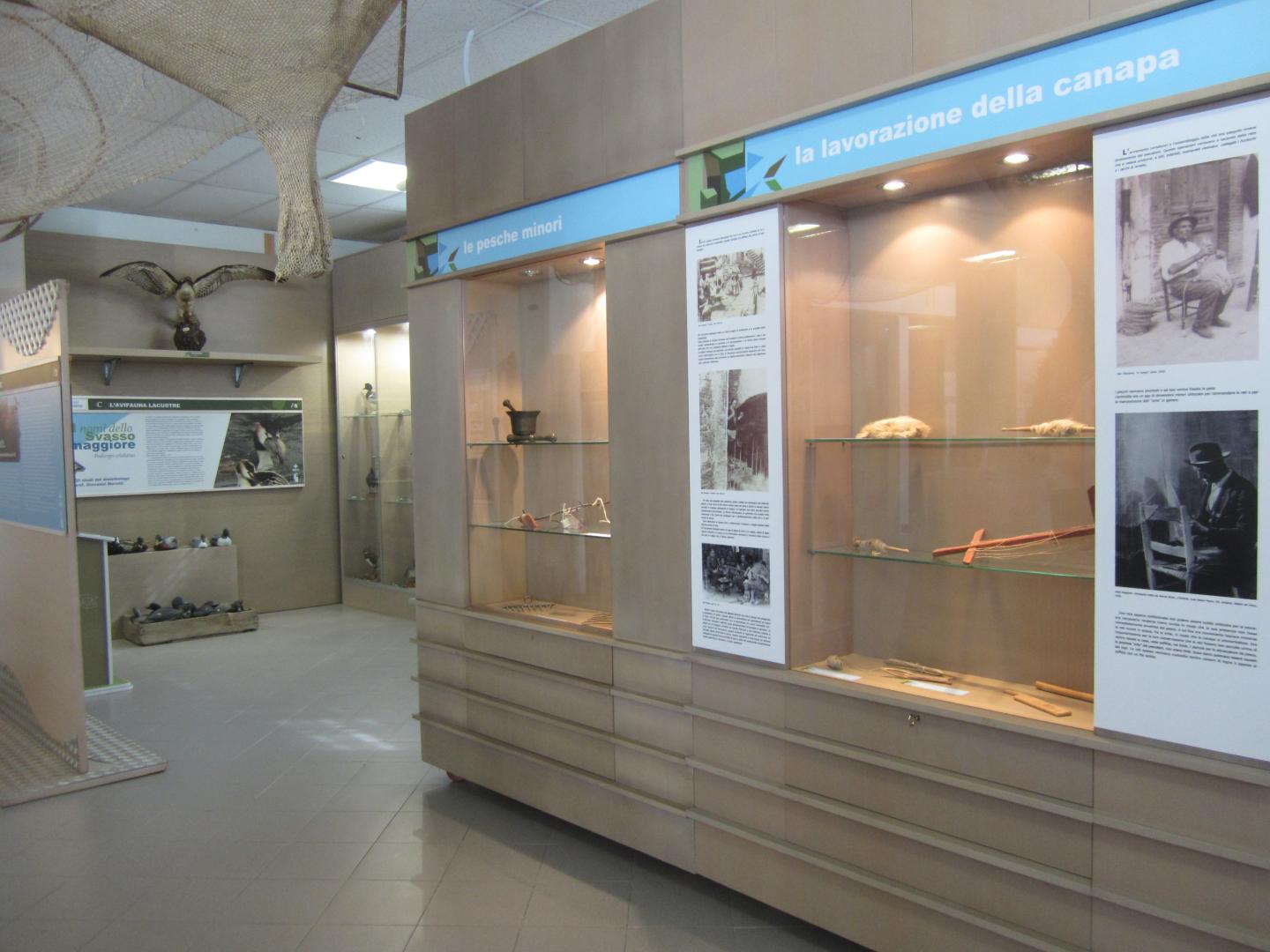 Esposizione al Museo della Pesca del Trasimeno con ceste intrecciate, attrezzi tradizionali e pannelli informativi.