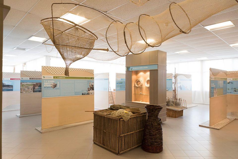 Allestimento del Museo della Pesca del Trasimeno con attrezzi tradizionali, reti e pannelli espositivi.