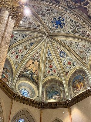 Detail of the frescoed dome of San Lorenzo Cathedral in Perugia with geometric motifs and sacred figures.