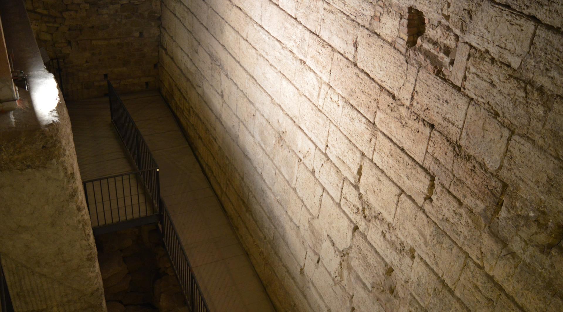 Part of the underground route of Perugia Underground after the great retaining wall of the acropolis made of square blocks of travertine is seen