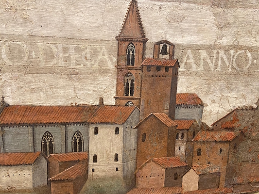 Detail of a painting with a medieval urban view, towers and red roofs in the foreground.