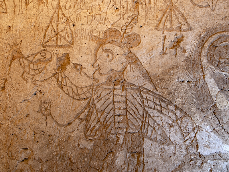 Drawings and symbols engraved on the wall of the Chamber of Torments, including human figures, crosses and enigmatic motifs.