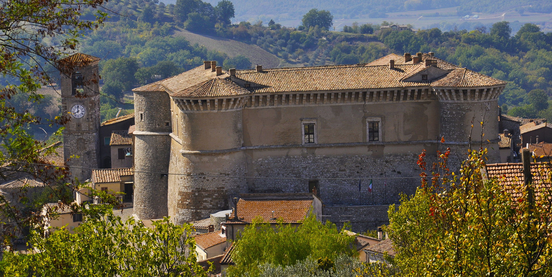View of the Rocca of Alviano, a majestic medieval fortress surrounded by the village and the Umbrian hills.