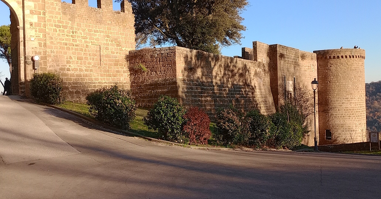 Albornoz-Festung von Orvieto bei Sonnenuntergang, mit Mauern aus Tuffstein, einem runden Turm und dem Haupteingang