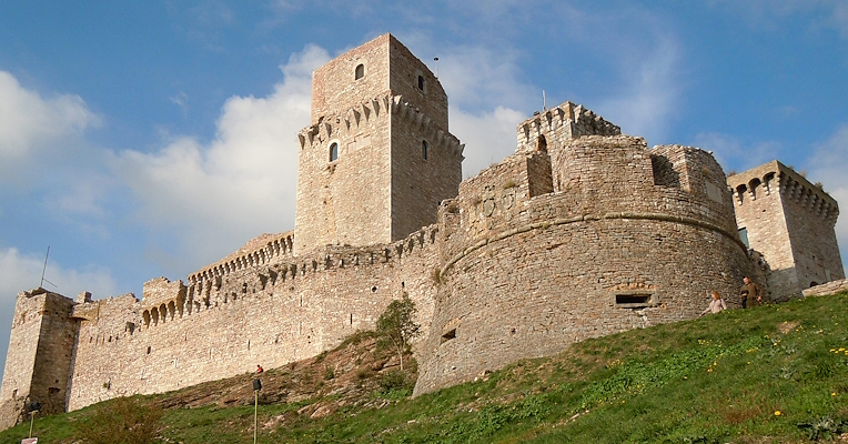 Blick von unten auf die imposante Albornoz-Festung von Assisi, mit dem zentralen Bergfried und der mächtigen Rundbastion auf der rechten Seite