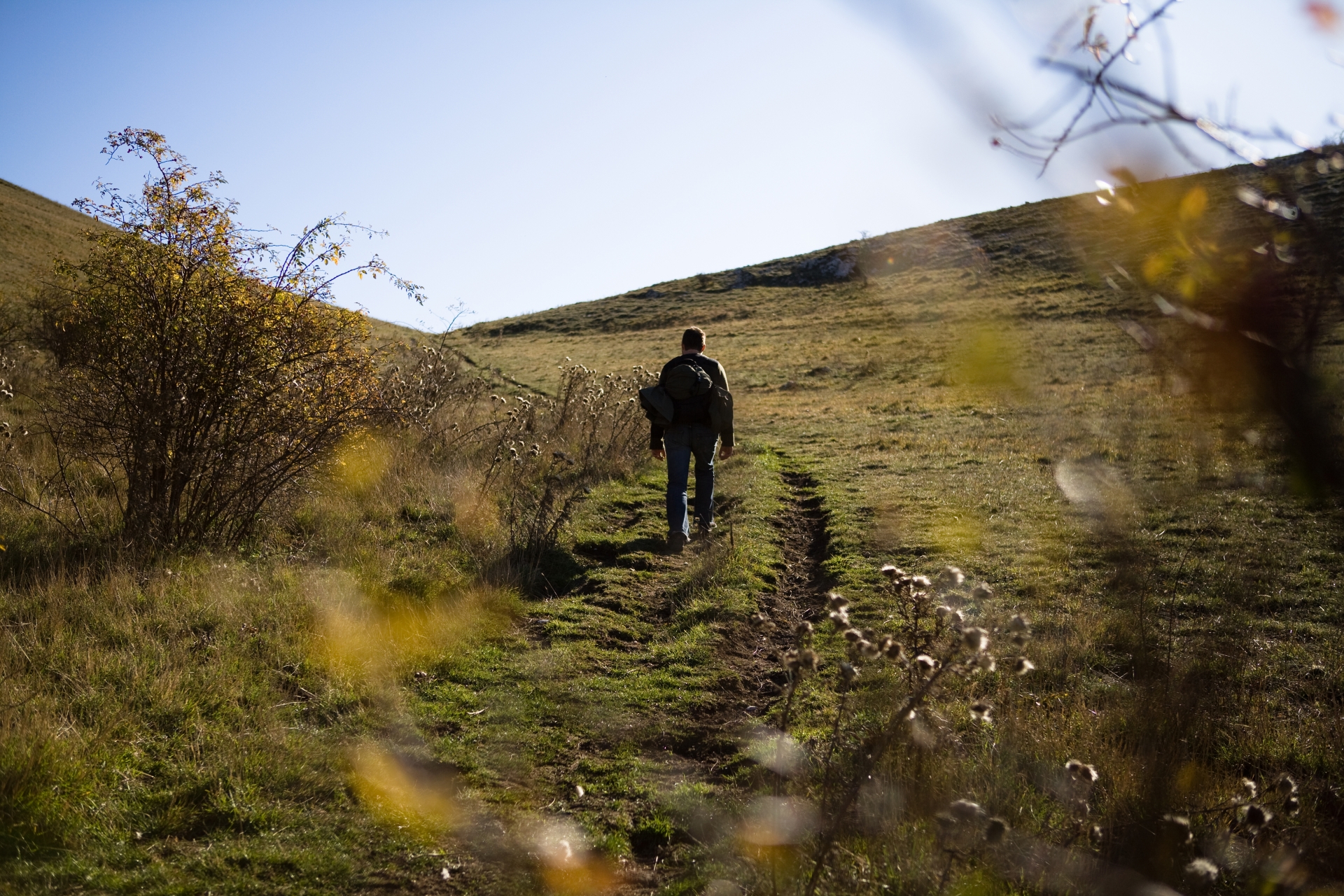 Ein Mann wandert in den offenen Bergen von Assisi mit einer Trekkingausrüstung