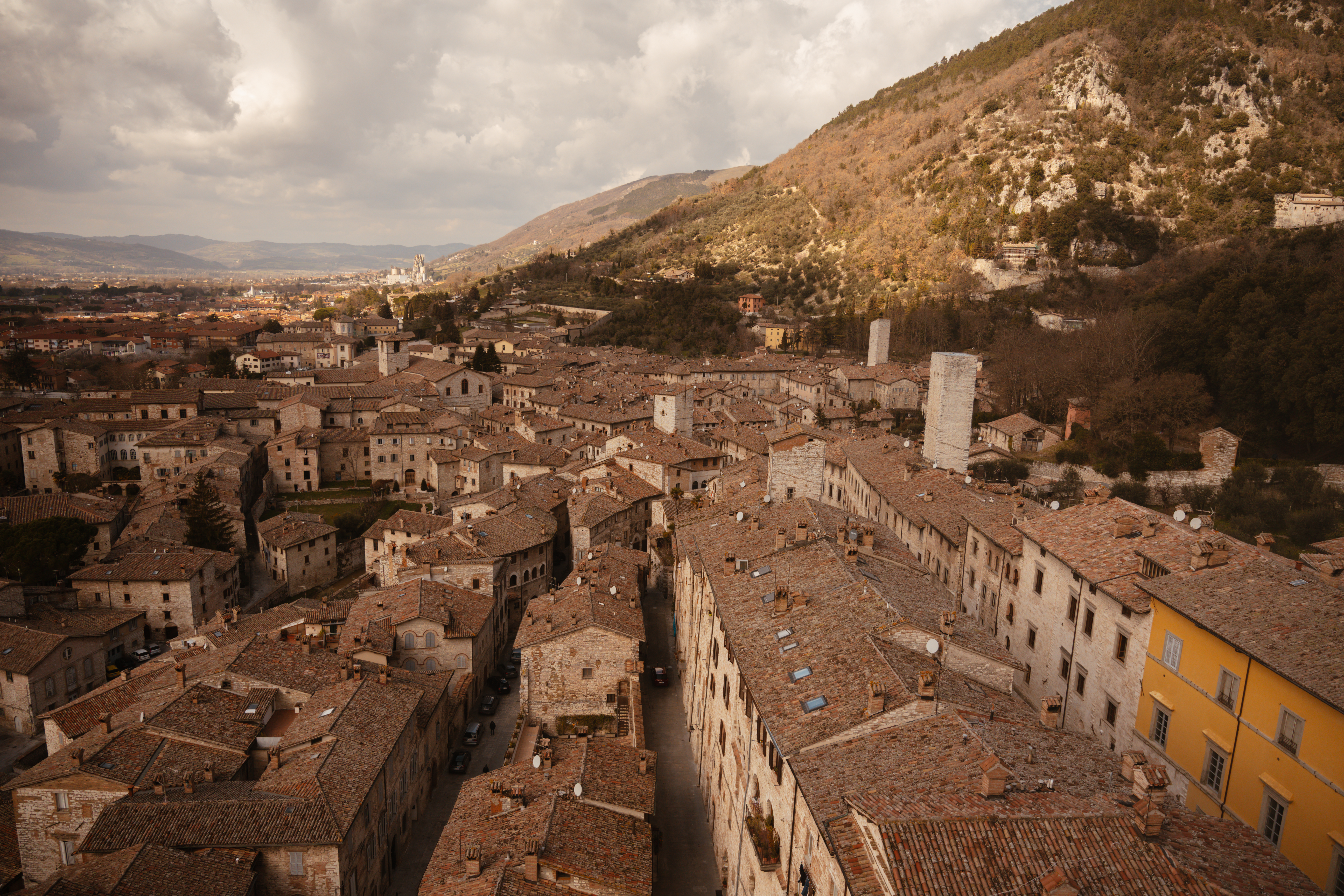 Luftaufnahme der Stadt Gubbio mit dem Monte Ingino im Hintergrund.