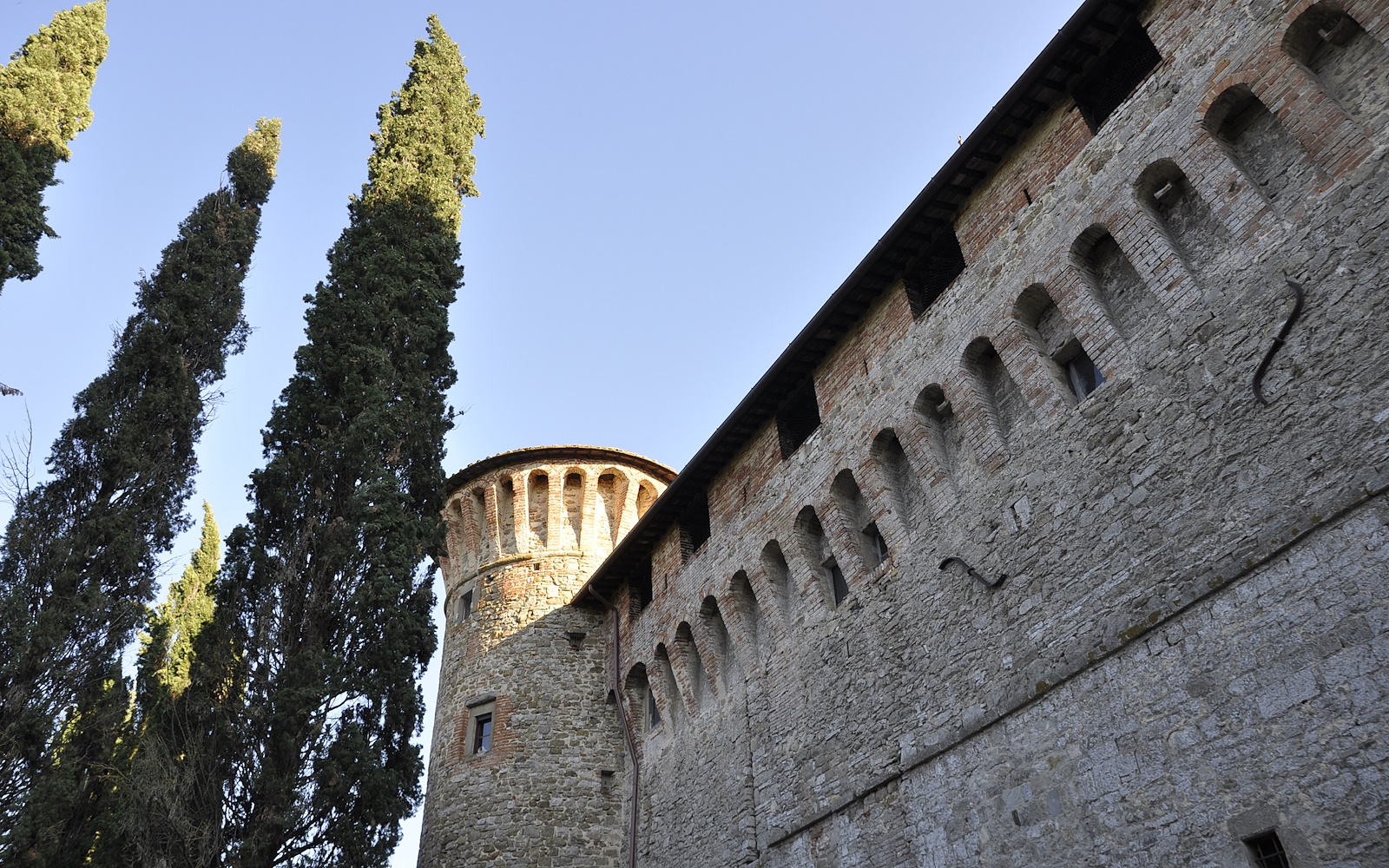 In the foreground, the imposing walls and a massive tower of the Knights of Malta Castle are visible.