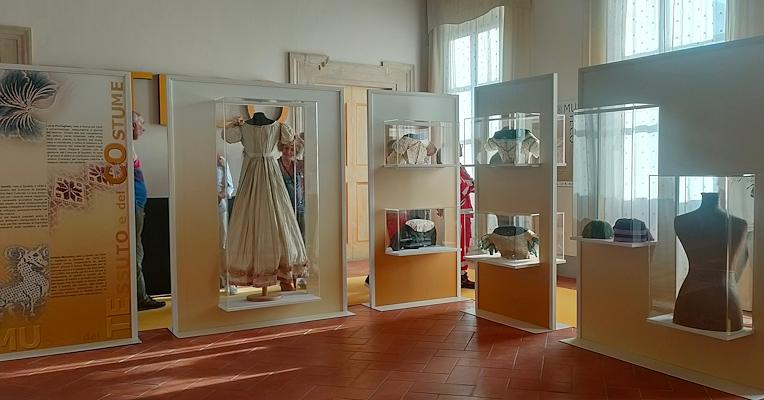 Immagine del Salone d’ingresso al Museo del Tessuto e del costume con teche espositive