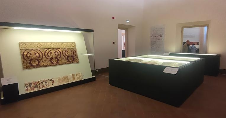 Interno della stanza dei paramenti sacri con in primo piano la teca Antependium in rosso e oro e paliotto d’altare