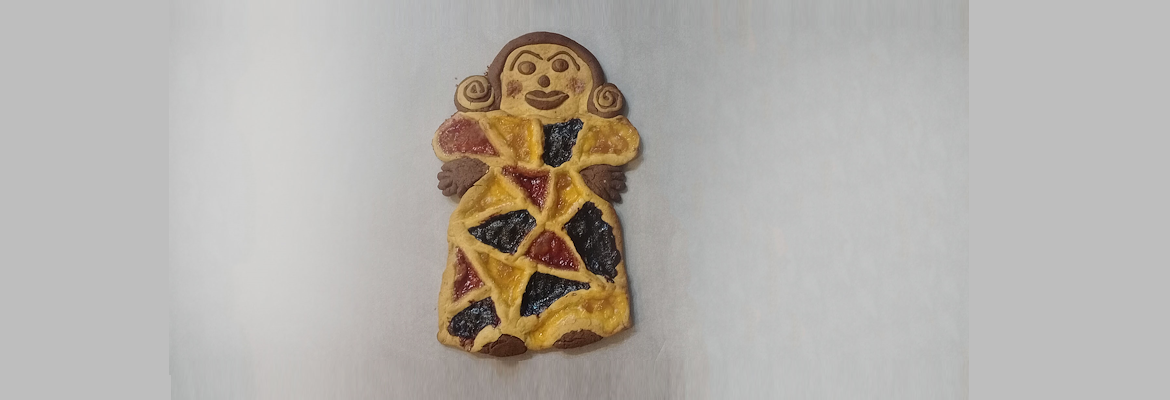 Zweifarbige Tarte in Form einer weiblichen Figur, dekoriert mit bunten Marmeladen und handgefertigten Details.