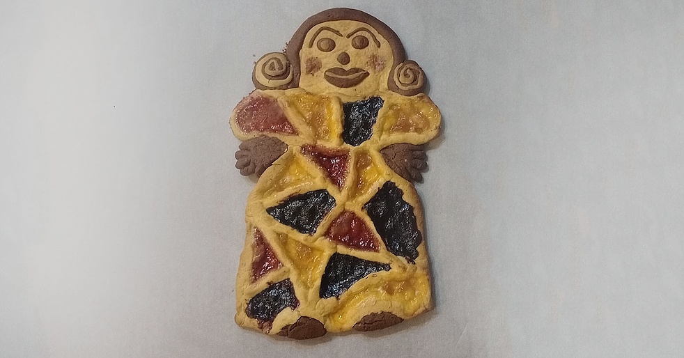 Zweifarbige Tarte in Form einer weiblichen Figur, dekoriert mit bunten Marmeladen und handgefertigten Details.