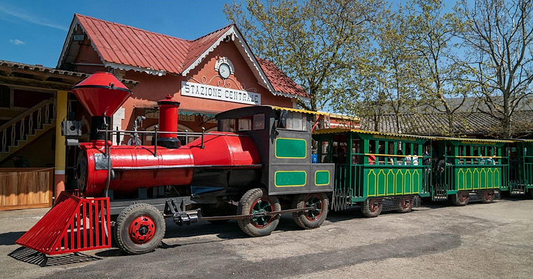 Bunter kleiner Zug hält am Bahnhof der Città della Domenica