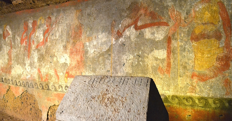 Urn with inscription placed in front of the polychrome wall painting of the Tomb of the Hescanas