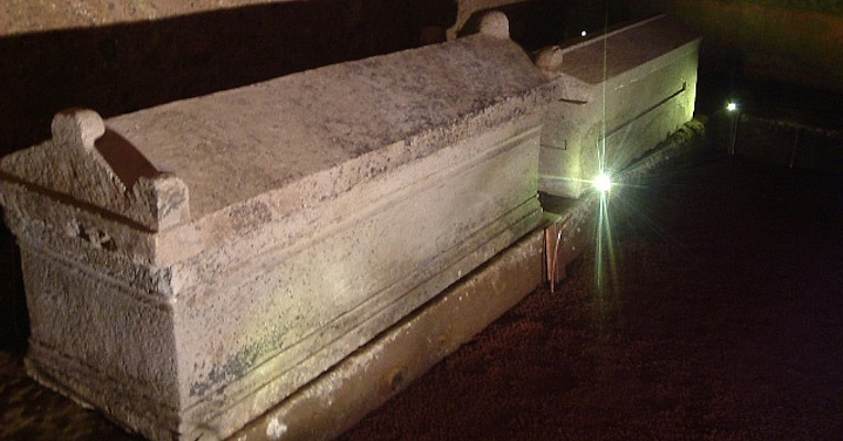 Interior of the Tomb of the Hescanas with stone sarcophagi and urns placed on the bench running along the walls