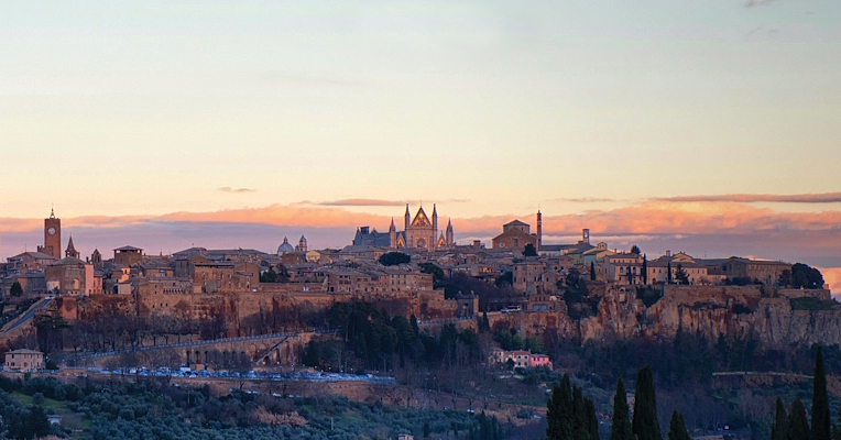  Panoramic view of the city of Orvieto illuminated by the sunset light, resting on its tuff cliff. 