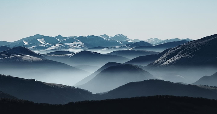 Berge des Regionalparks Monte Cucco, eingehüllt in Nebel und winterlichen Frost.