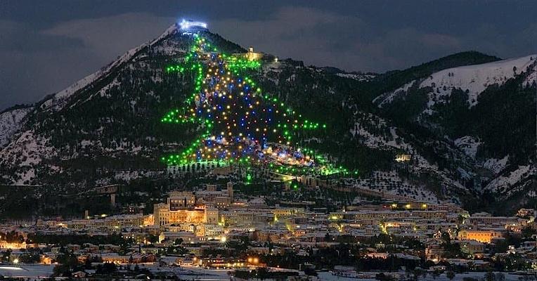 Panoramica notturna di Gubbio con l’Albero di Natale luminoso sul Monte Ingino che domina la città.
