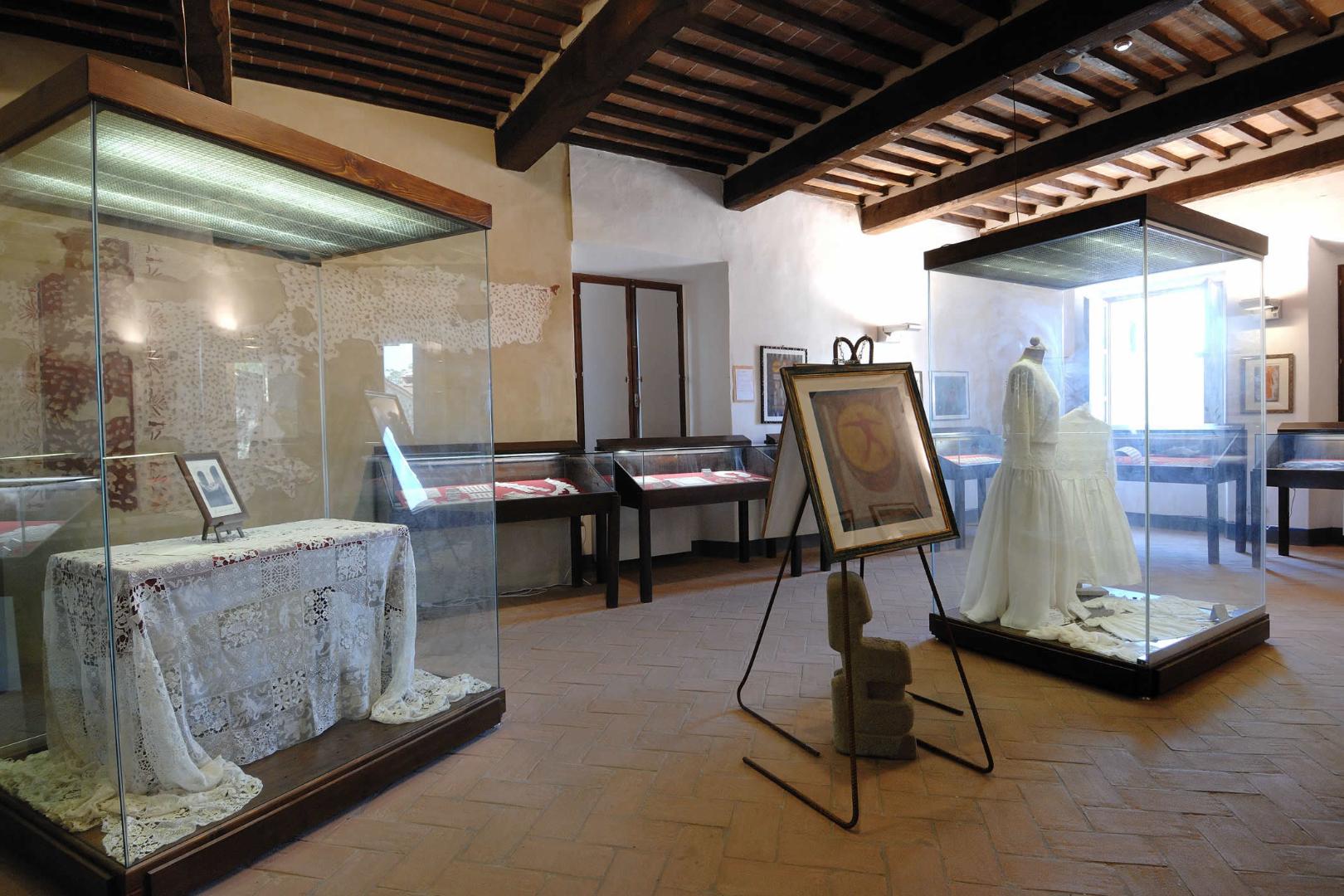 Wide view of a room in the Lace Museum, showcasing various textile works, including fine lace and embroidered fabrics