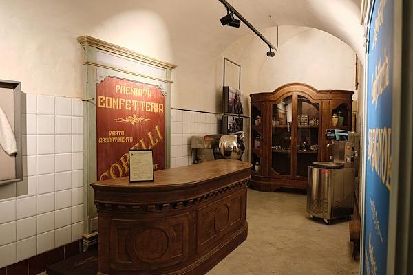 Reconstruction of an old confectionery, with a wooden counter, period furnishings and historic chocolate-making machines.